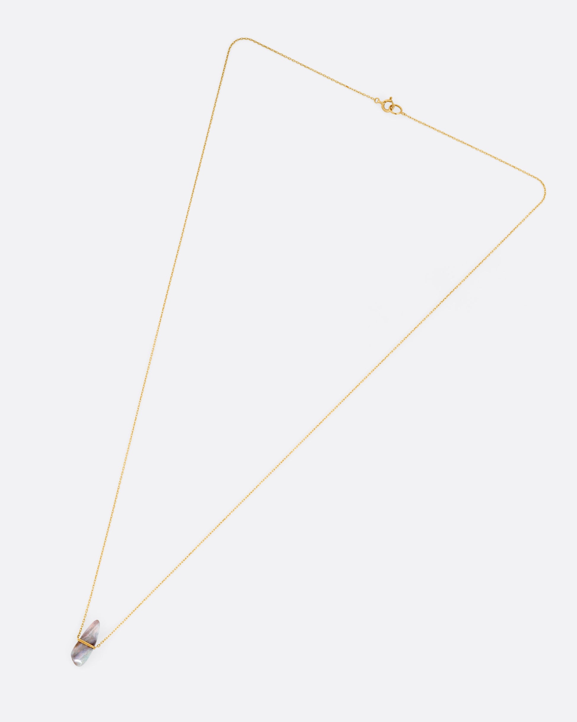 A yellow gold necklace with a freeform opal pendant, shown from the front.