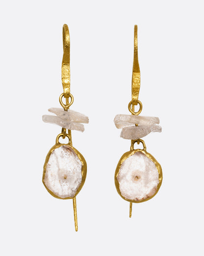 A pair of earrings with white quartz stacks, yellow gold ear hooks, and two front- facing gold wrapped quartz slices. Shown from the front.