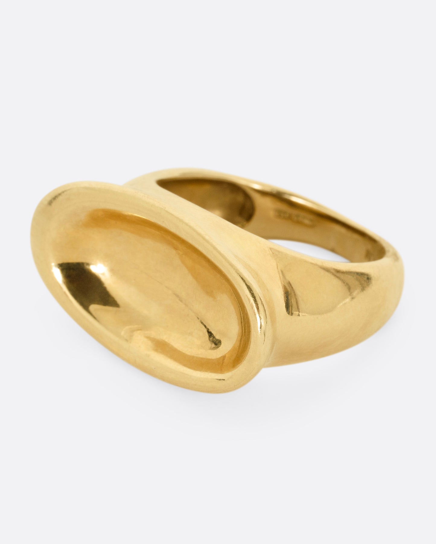 A yellow gold ring with a broad oval signet with a slight concave, shown from the side.