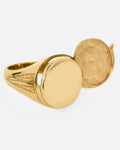 A yellow gold round-faced locket signet ring, shown from the side.