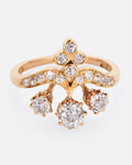 A rose and yellow gold ring with hand cut Old European diamonds in varying sizes, shown from the front.