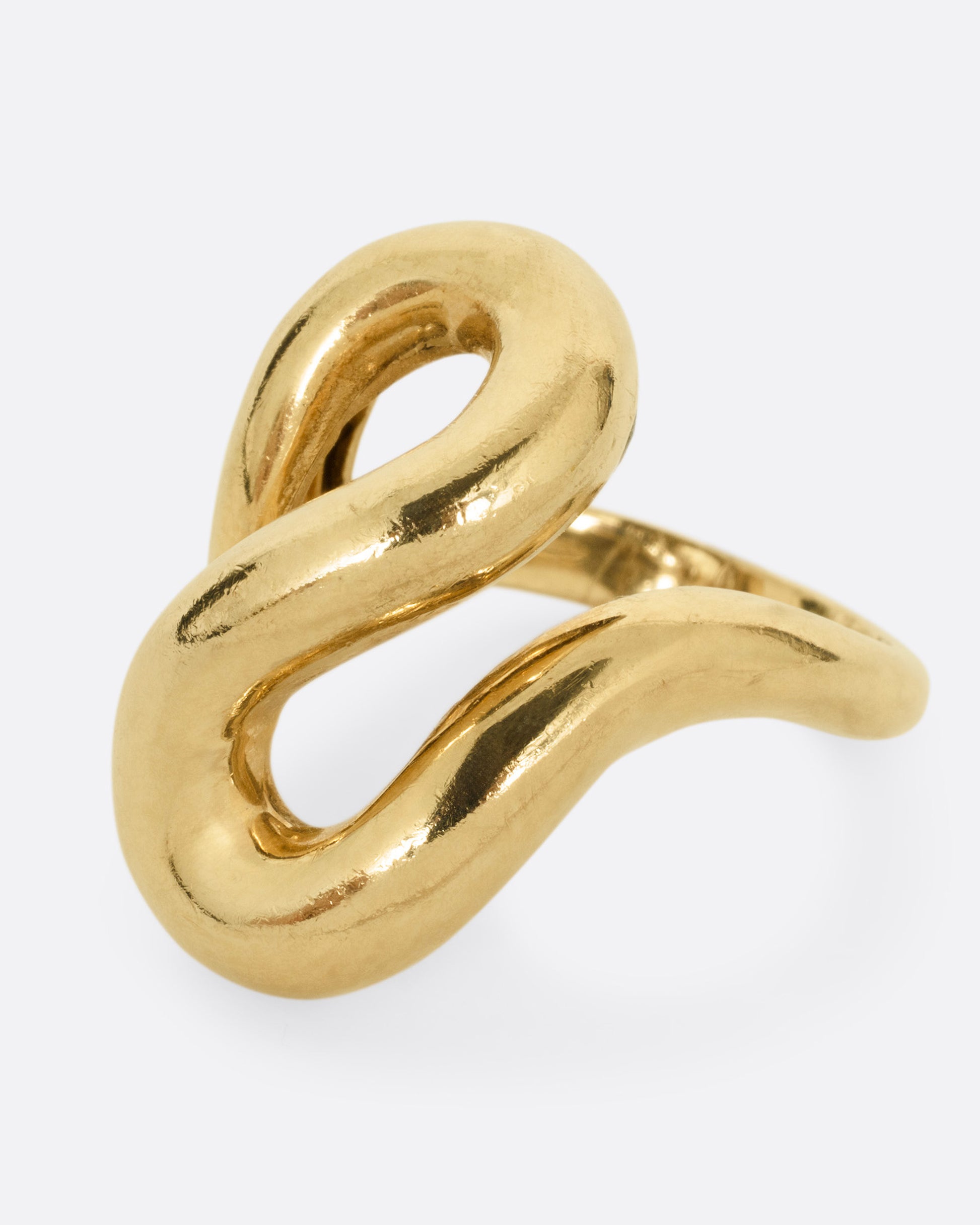 A yellow gold coiling ring, shown from the side.
