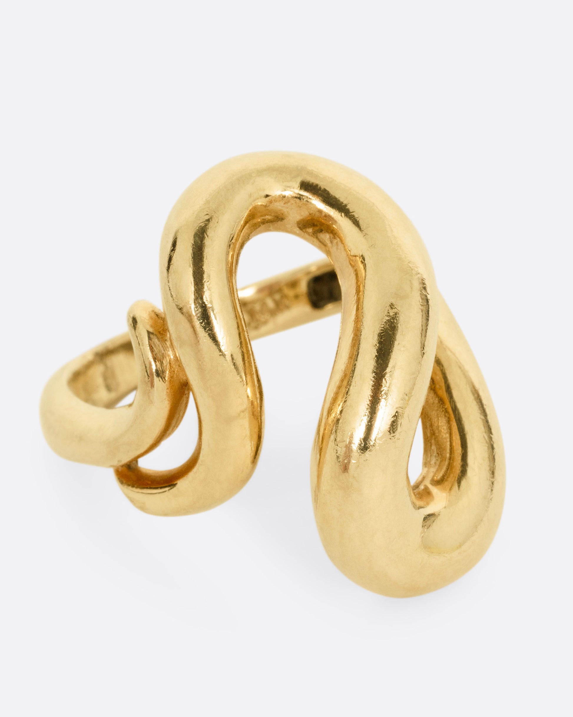 A yellow gold coiling ring, shown from the side.