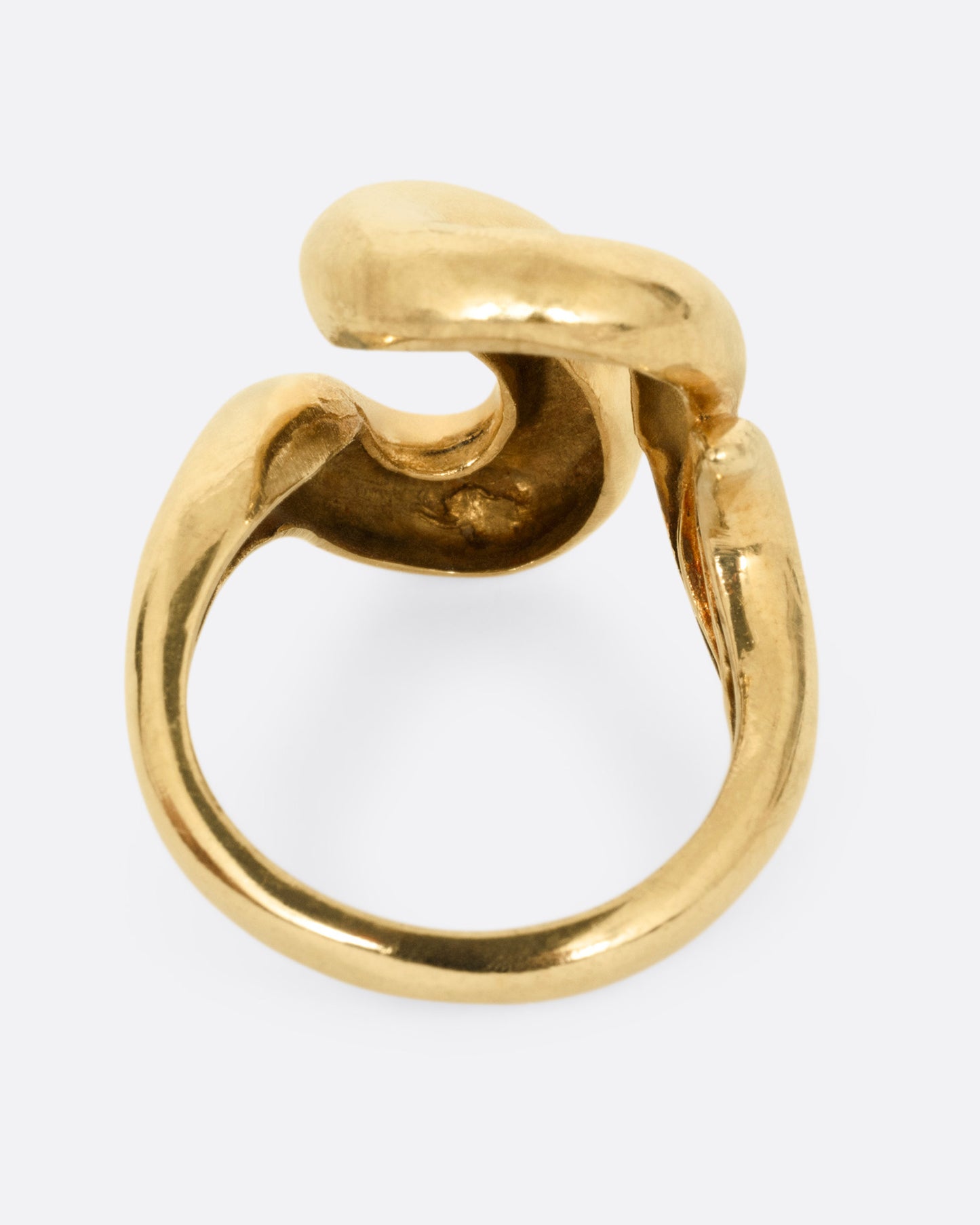 A yellow gold coiling ring, shown from the back.