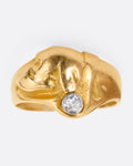 A yellow gold ring with the profile of a dog and a single diamond. Shown from the front.