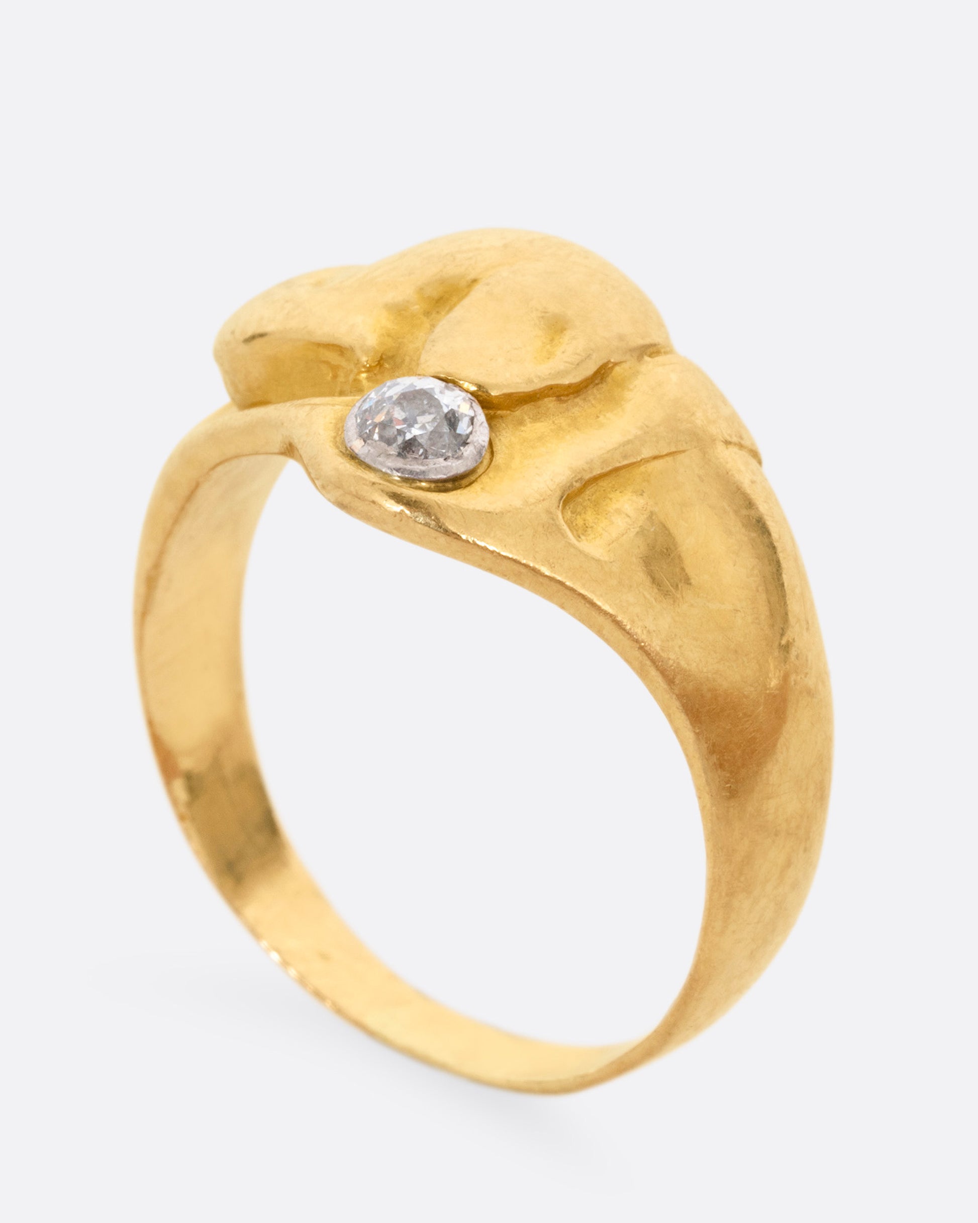 A yellow gold ring with the profile of a dog and a single diamond. Shown from the side standing up.