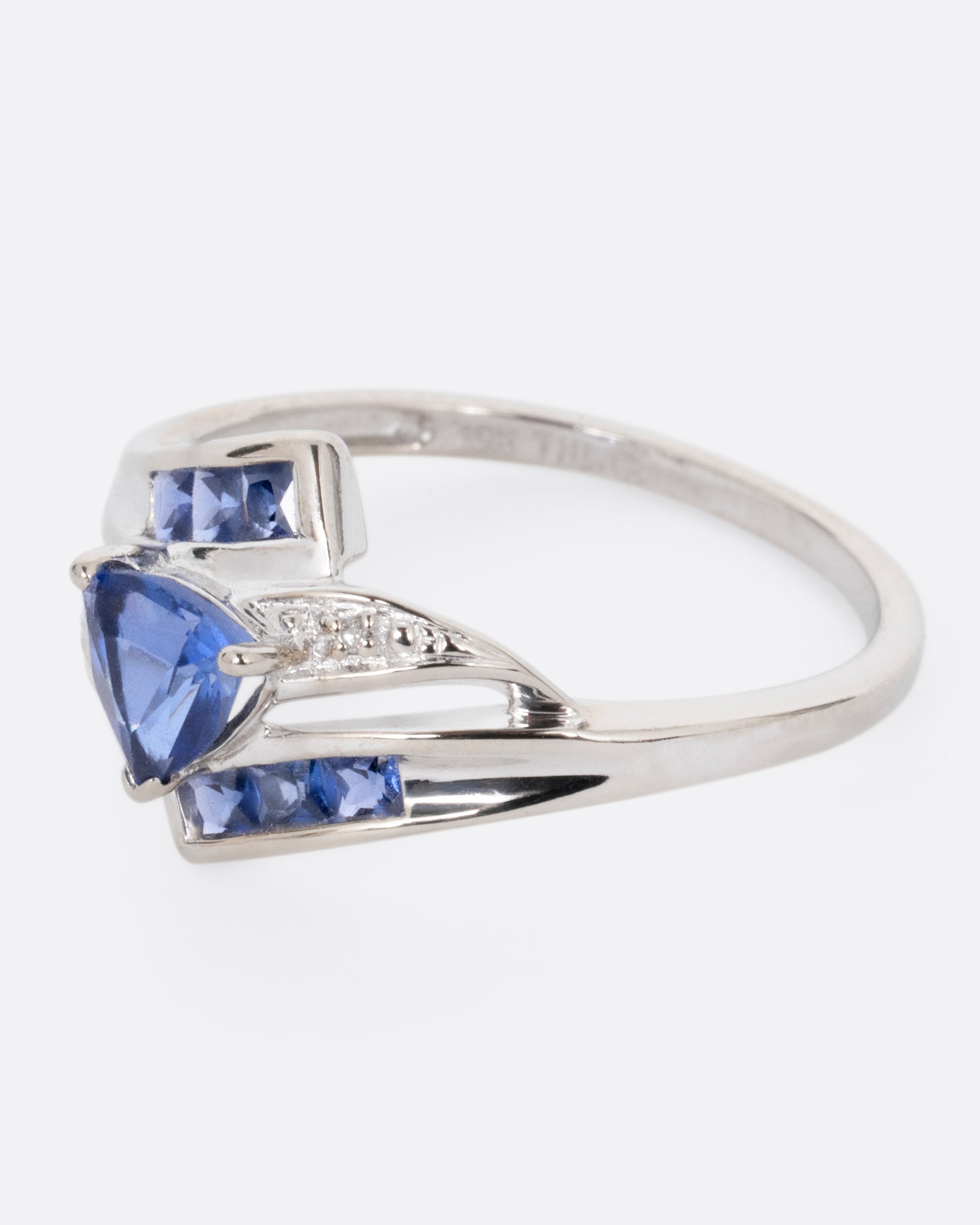 A white gold wrap wring with diamonds and sapphires, shown from the side.