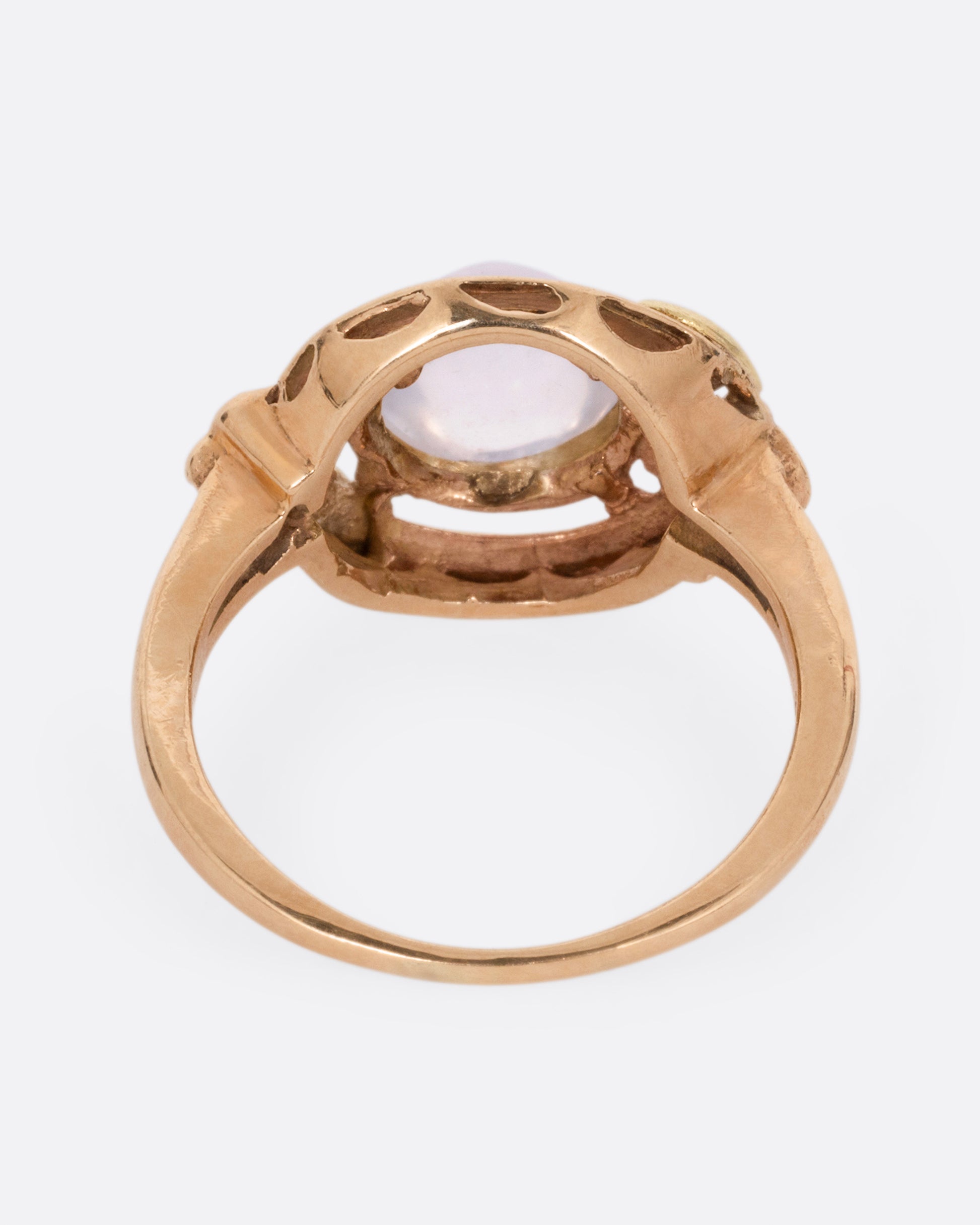 A rose and yellow gold moonstone cabachon ring, shown from the back.