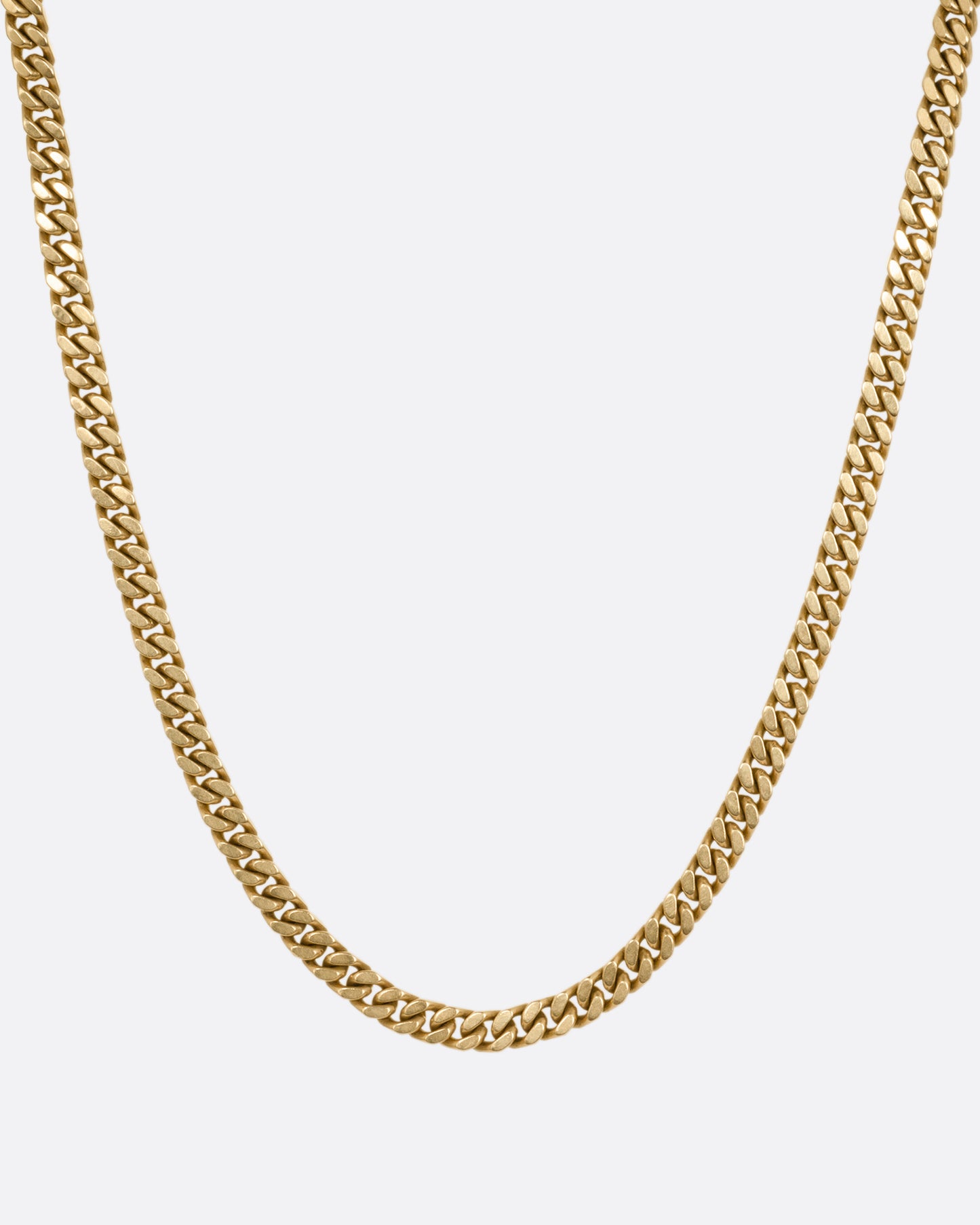 A yellow gold curb chain necklace, shown from the front.