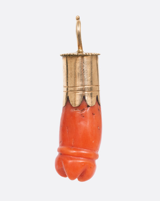 A yellow gold pendant with a carved coral penis, shown from the front.