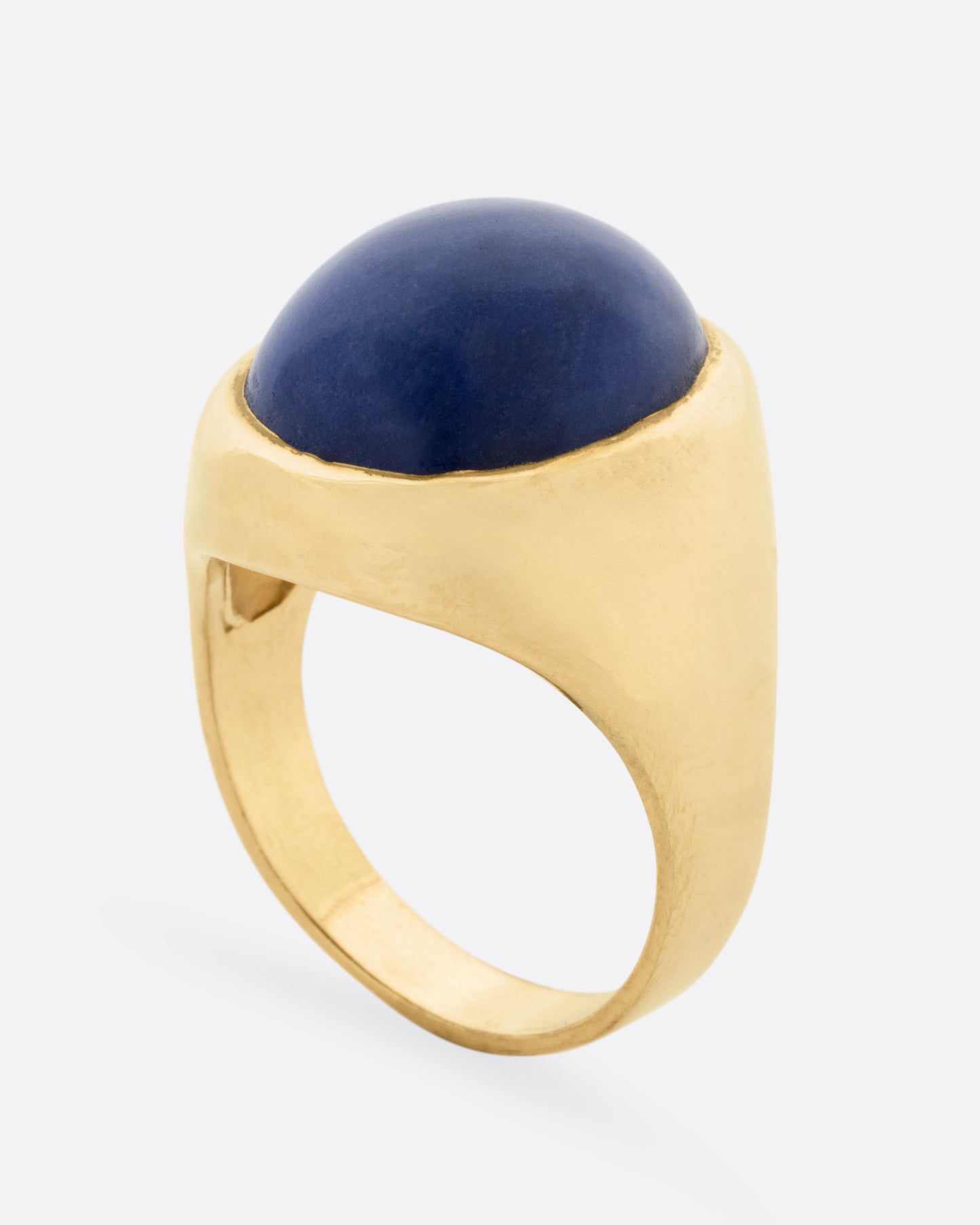 A yellow gold signet ring with a lapis cabochon, shown from the side standing up.