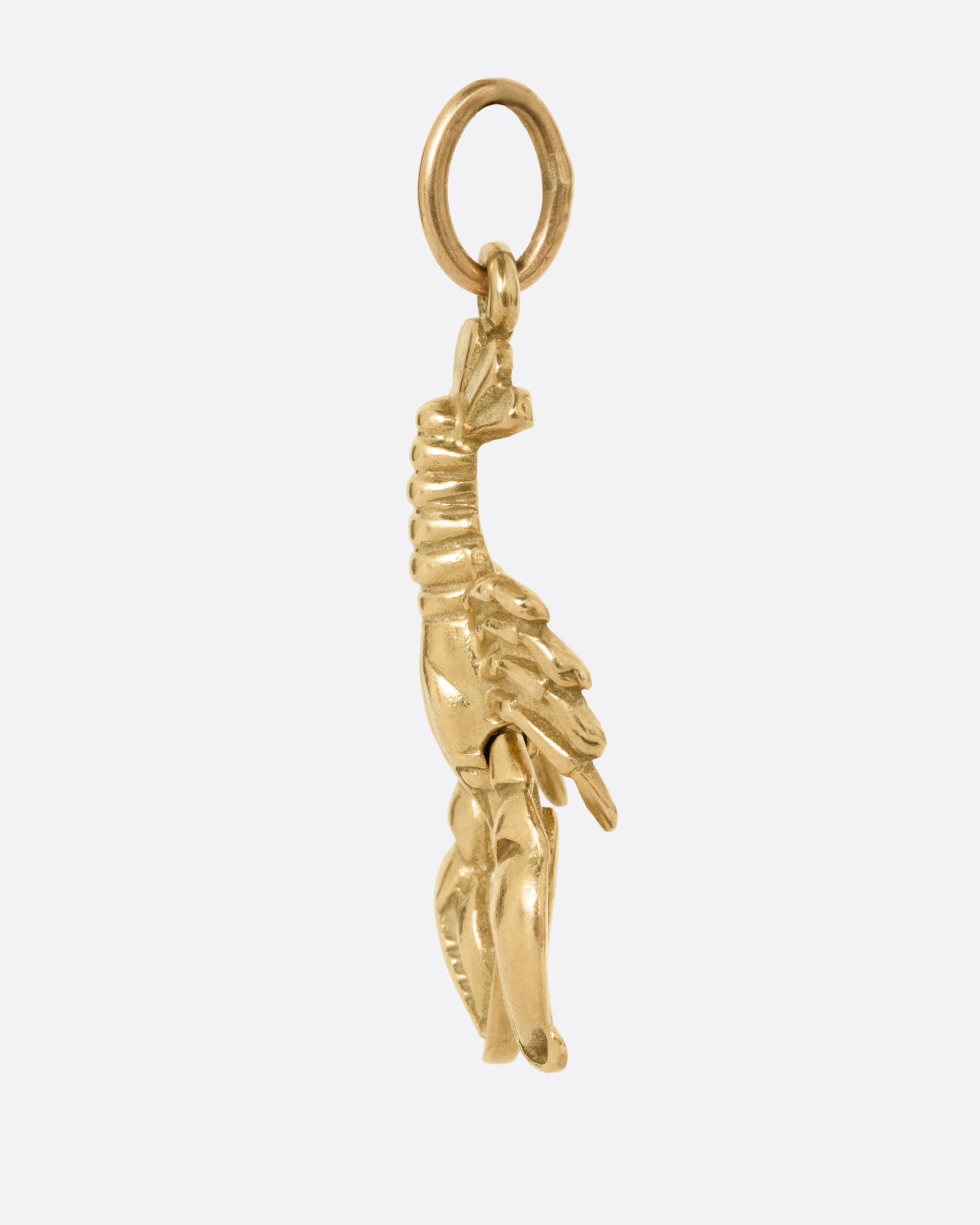 A yellow gold lobster charm, shown from the side.
