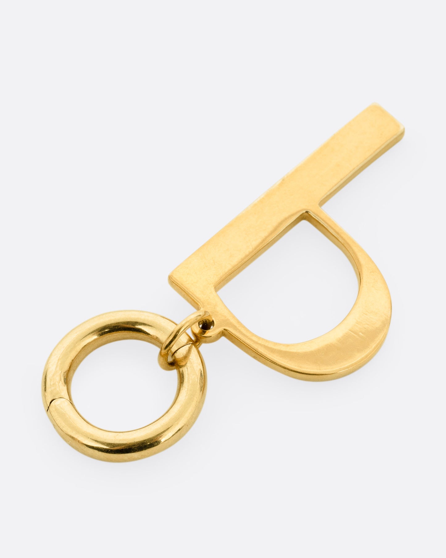 A yellow gold 'P' shaped pendant, shown from the side.