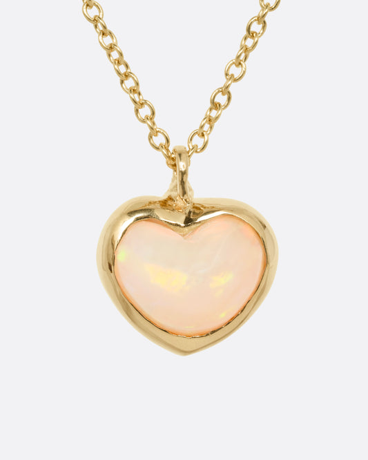 A yellow gold cable chain necklace with a large dimensional opal heart pendant, shown from the front.
