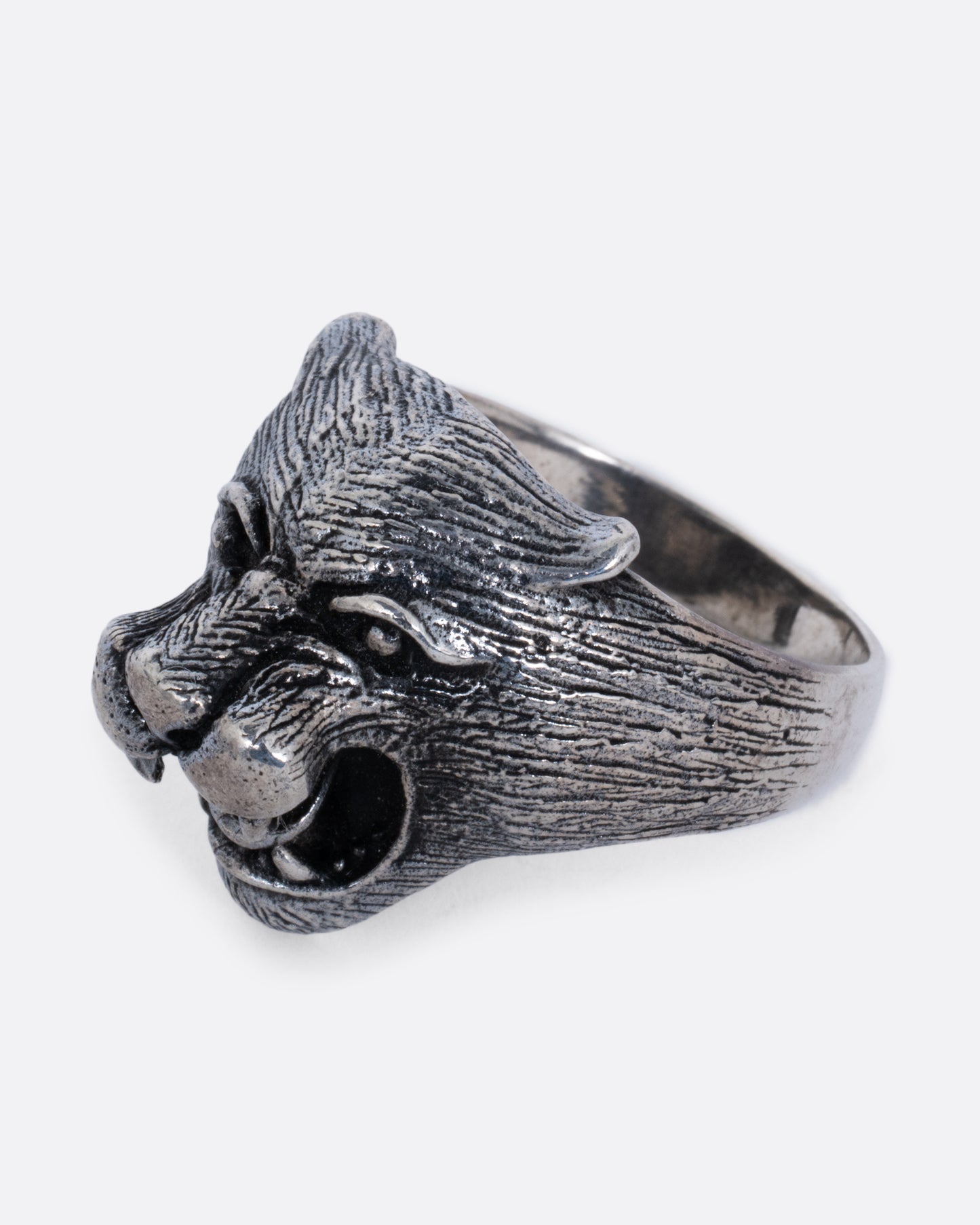 A sterling cougar head ring, shown from the side.