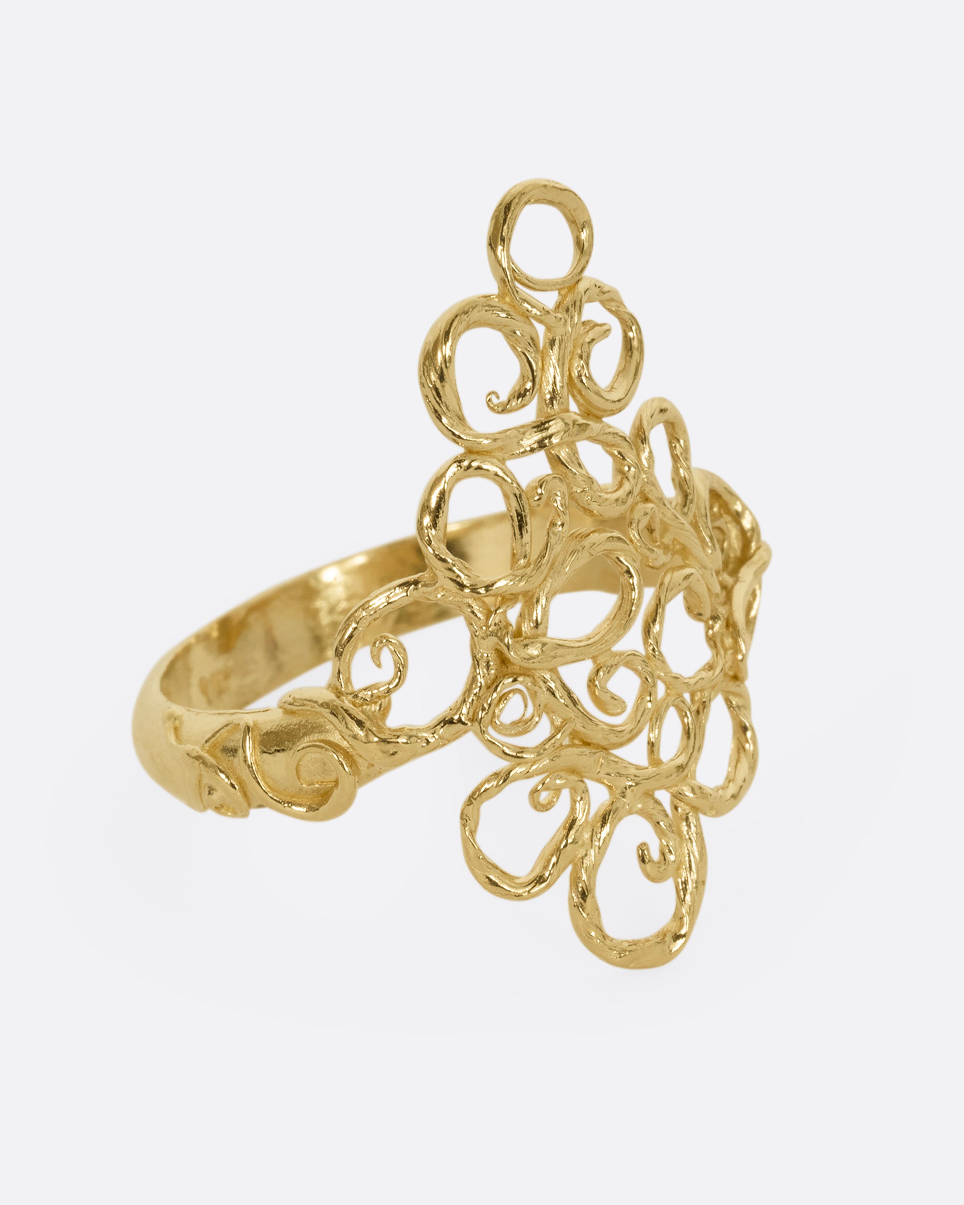 A yellow gold ring with filigree in the shape of a diamond at its center. Shown from the side.