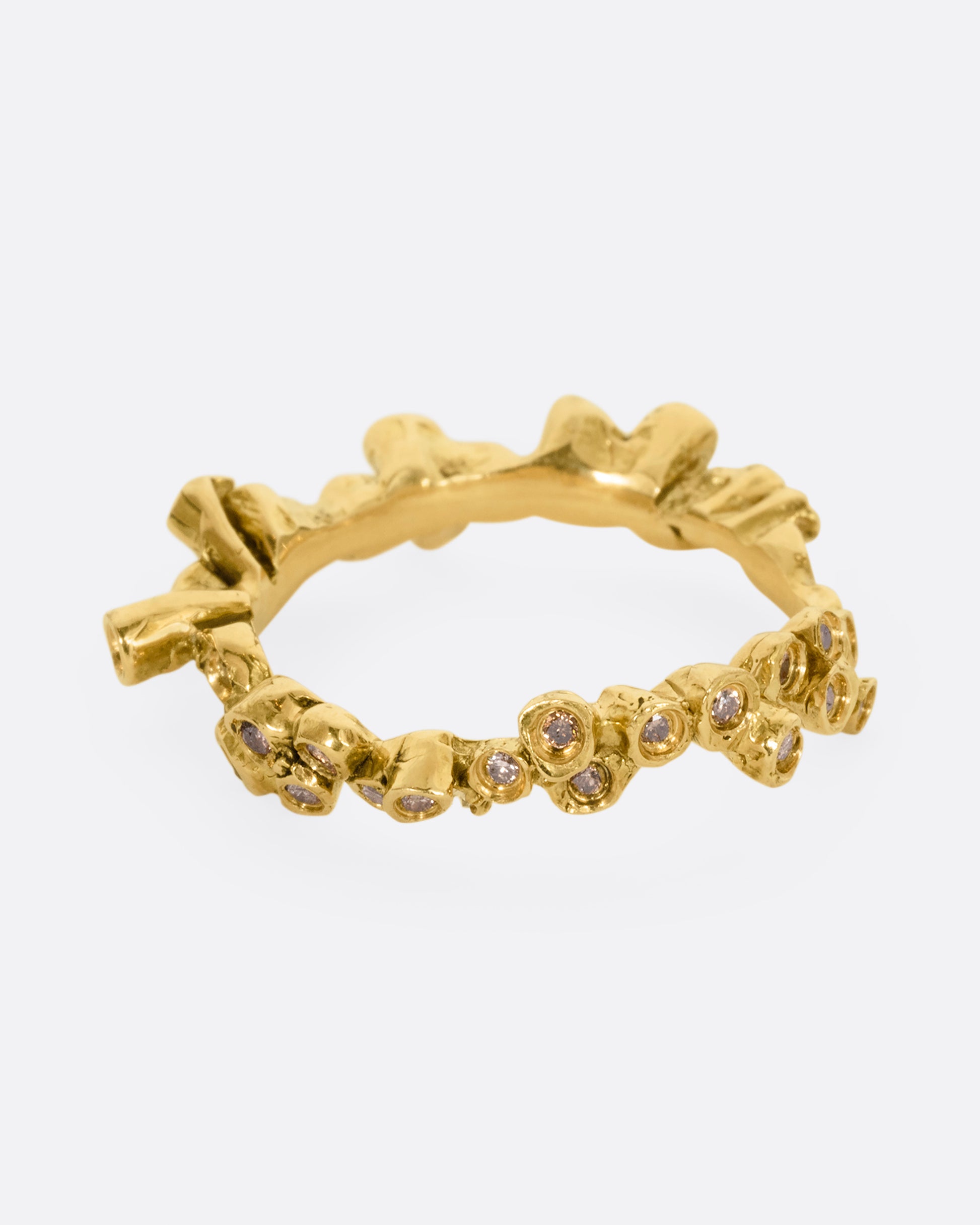 A yellow gold ring with cognac diamonds in protruding bezel settings that wrap around the entire band. Shown from the front.