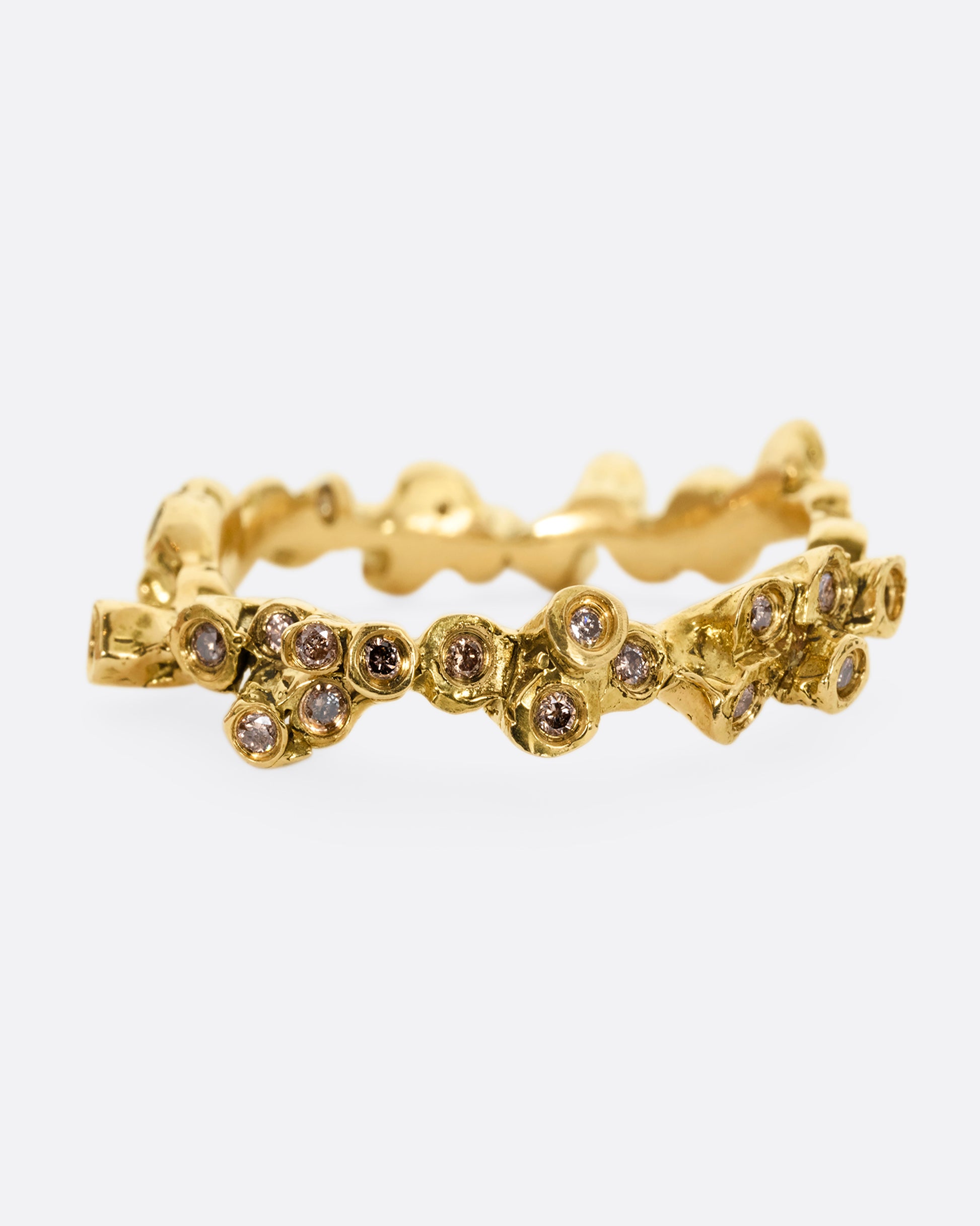 A yellow gold ring with cognac diamonds in protruding bezel settings that wrap around the entire band. Shown from the front.