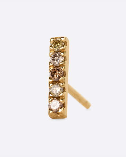 A yellow gold bar stud with a mix of five olive, dark and light champagne diamonds. Shown from the front.