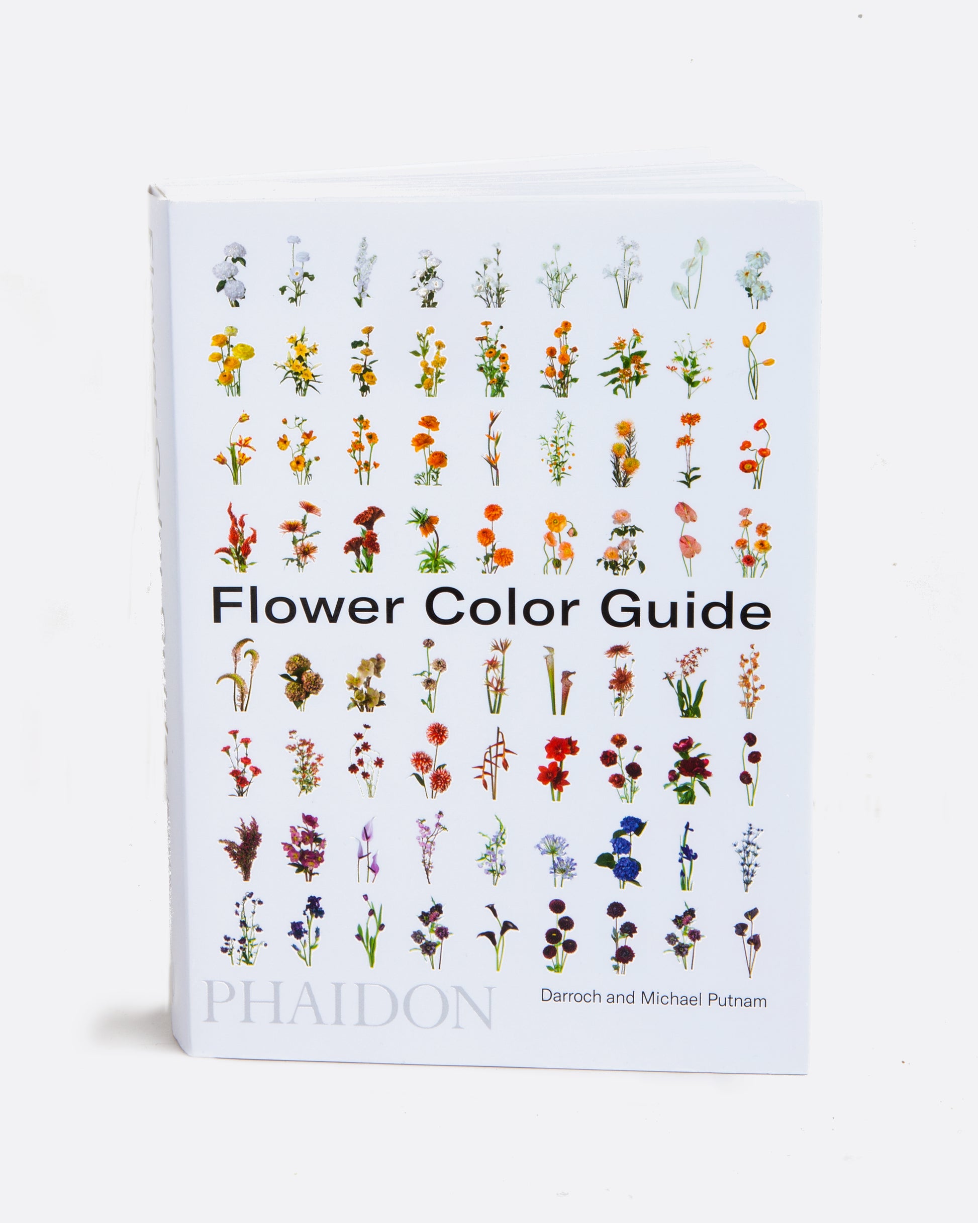 A book with a white cover with images of flowers in rows title Flower Color Guide. Shown standing up from the front.