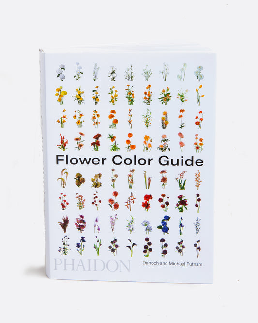 A book with a white cover with images of flowers in rows title Flower Color Guide. Shown standing up from the front.