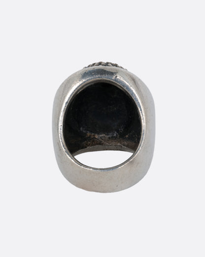 A silver ring with the Buddha's face. Shown from the back.