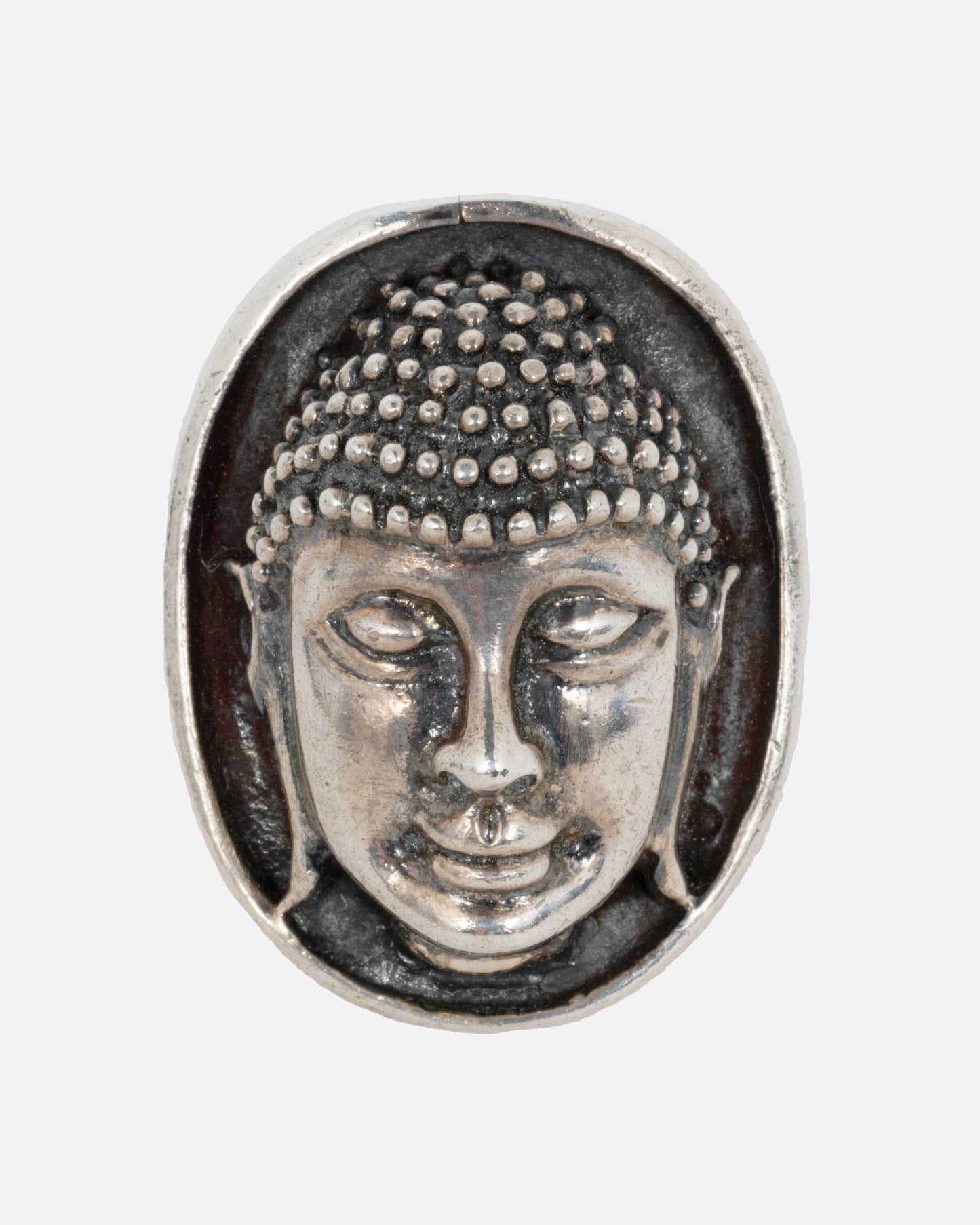 A silver ring with the Buddha's face. Shown from the front.