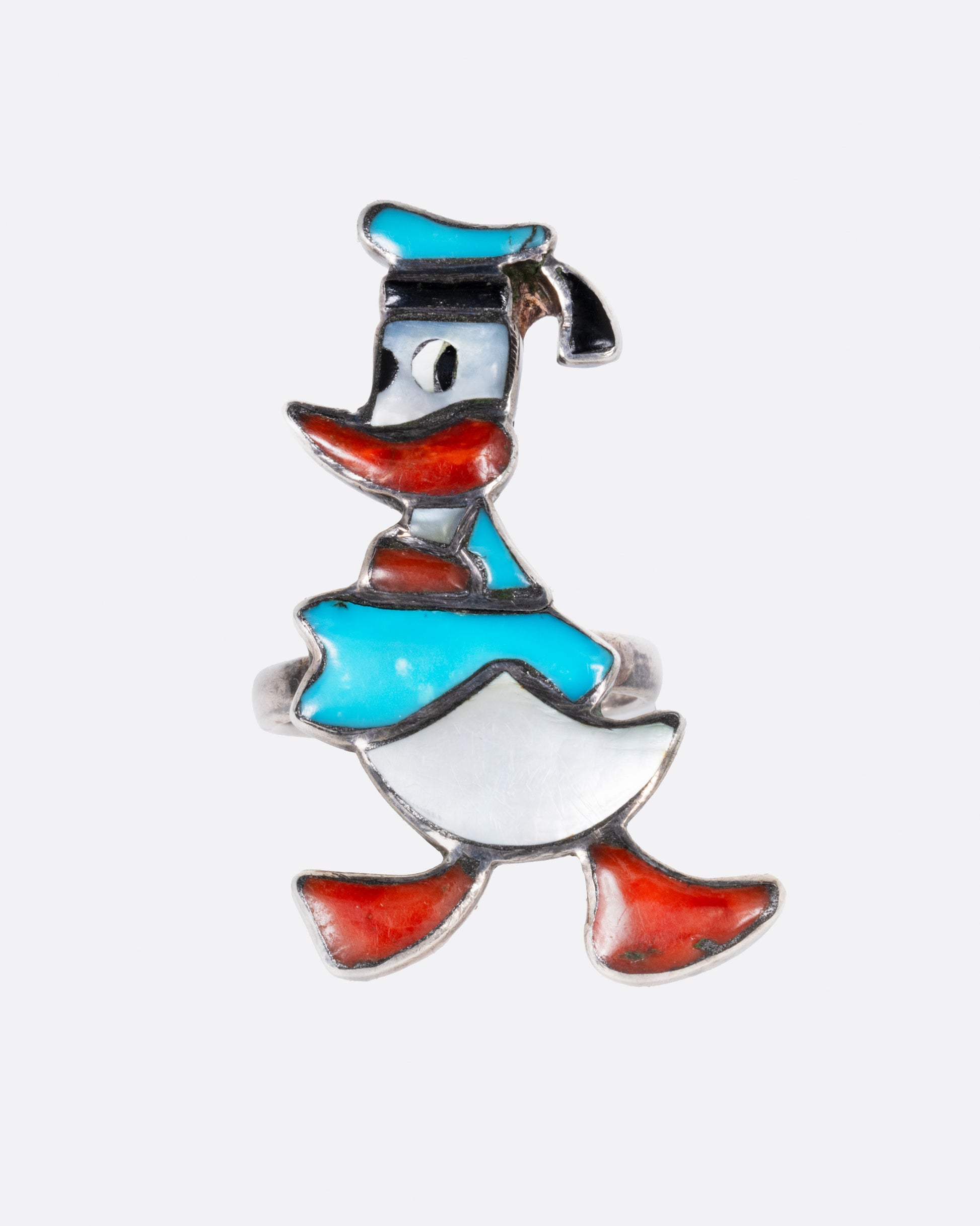A Donald Duck ring with turquoise and mother-of-pearl inlay. Shown from the front.