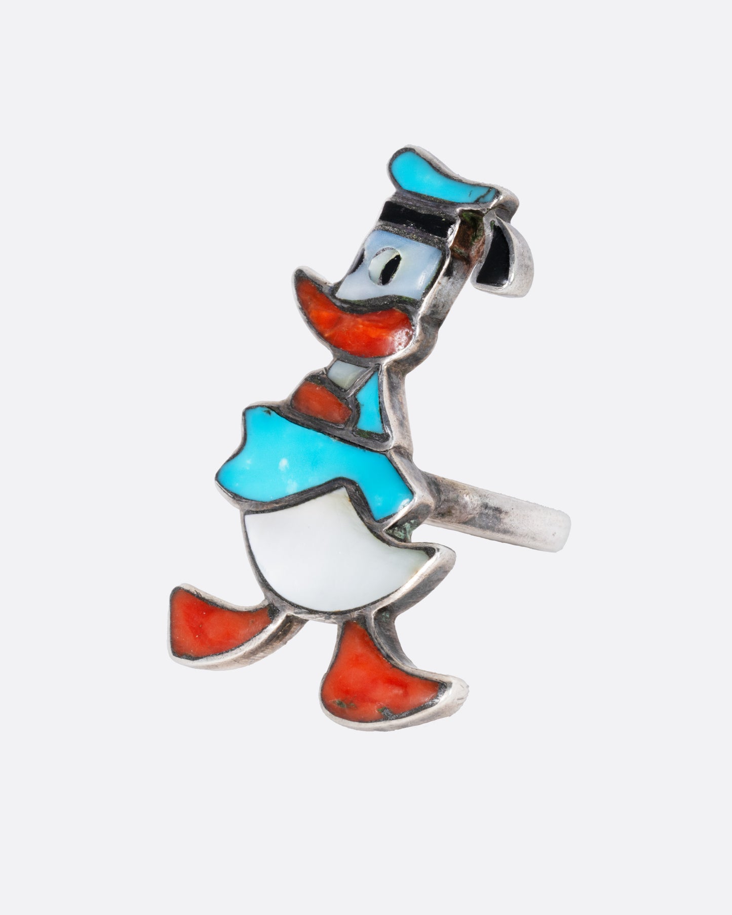 A Donald Duck ring with turquoise and mother-of-pearl inlay. Shown from the side.