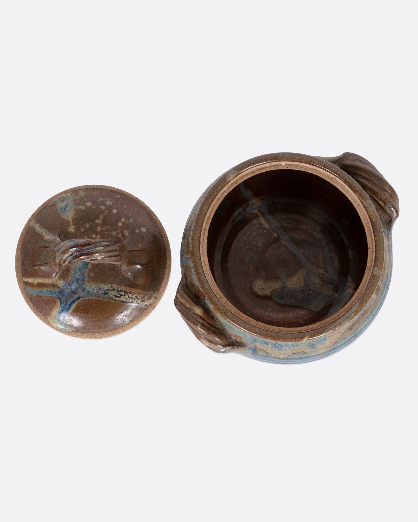 A ceramic pot with blue and brown glaze, dual handles, and a handled lid. Shown from the top with the top off.