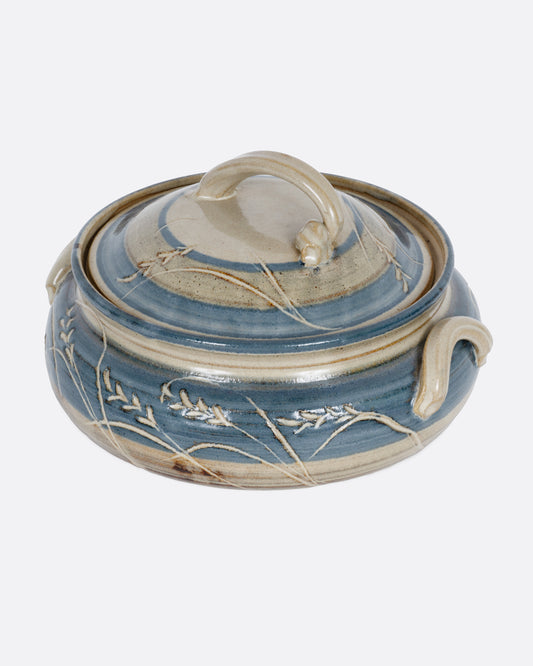 A blue and gray casserole dish with a domed lid and handles. Shown from the side.