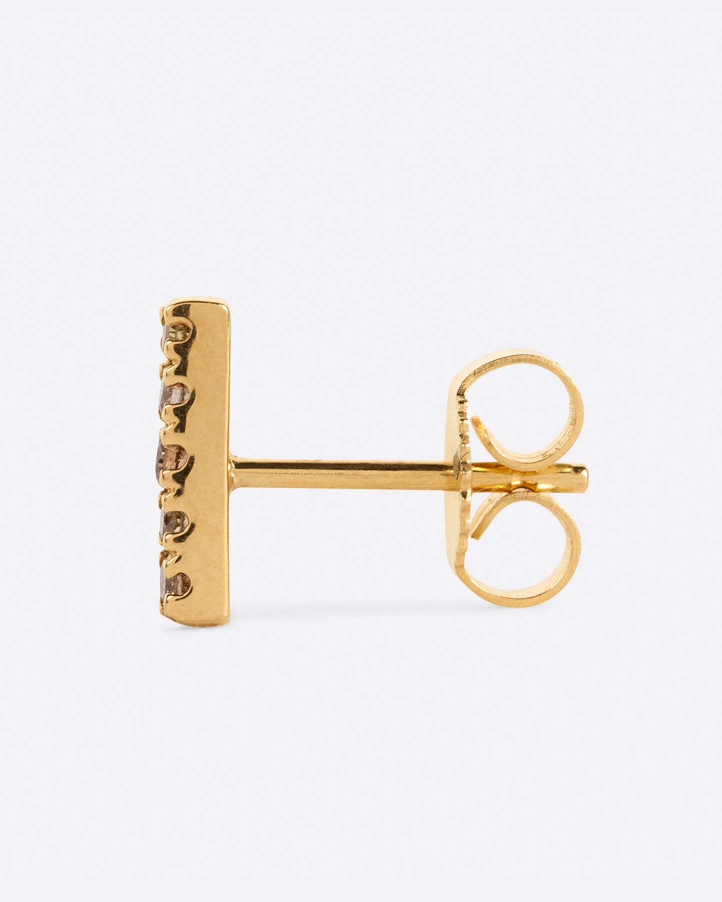 A yellow gold bar stud with a mix of five olive, dark and light champagne diamonds. Shown from the side.