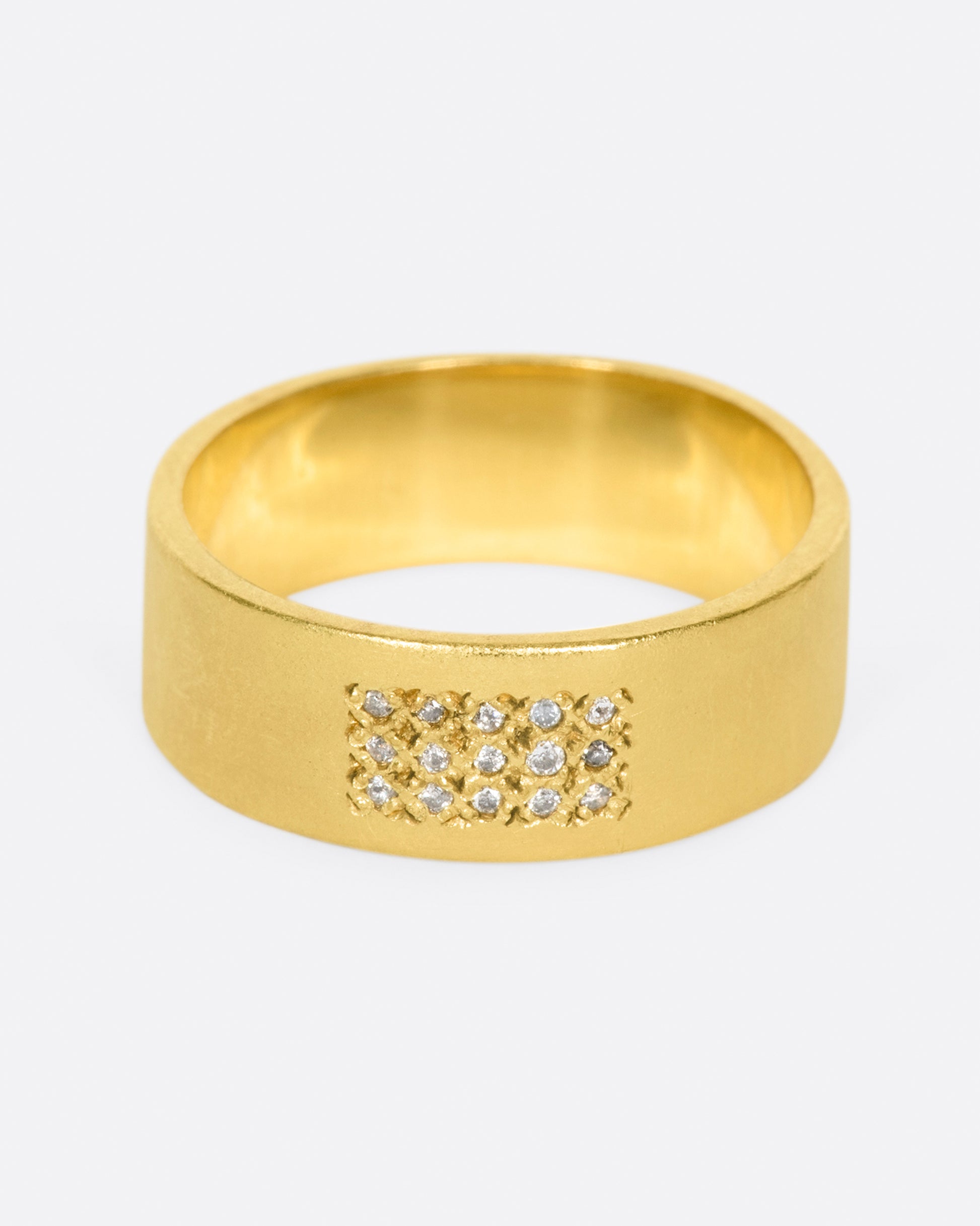 A yellow gold band with 15 grey diamonds in three rows of five at the center. Shown from the front.