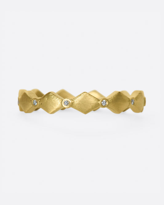 A geometric band with alternating round diamonds and matte gold shapes.