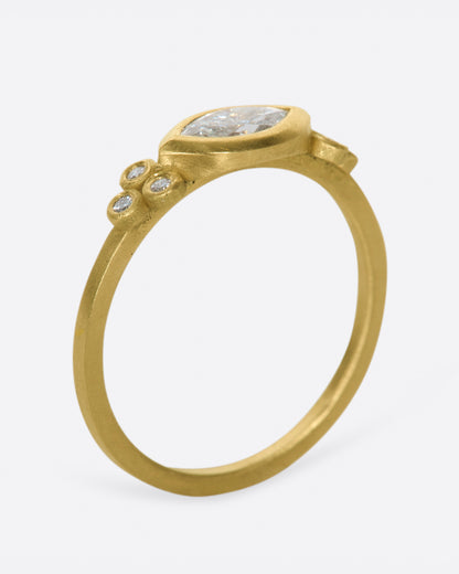 Yellow gold marquise diamond ring, angled view showing the bezel on top of the slim band