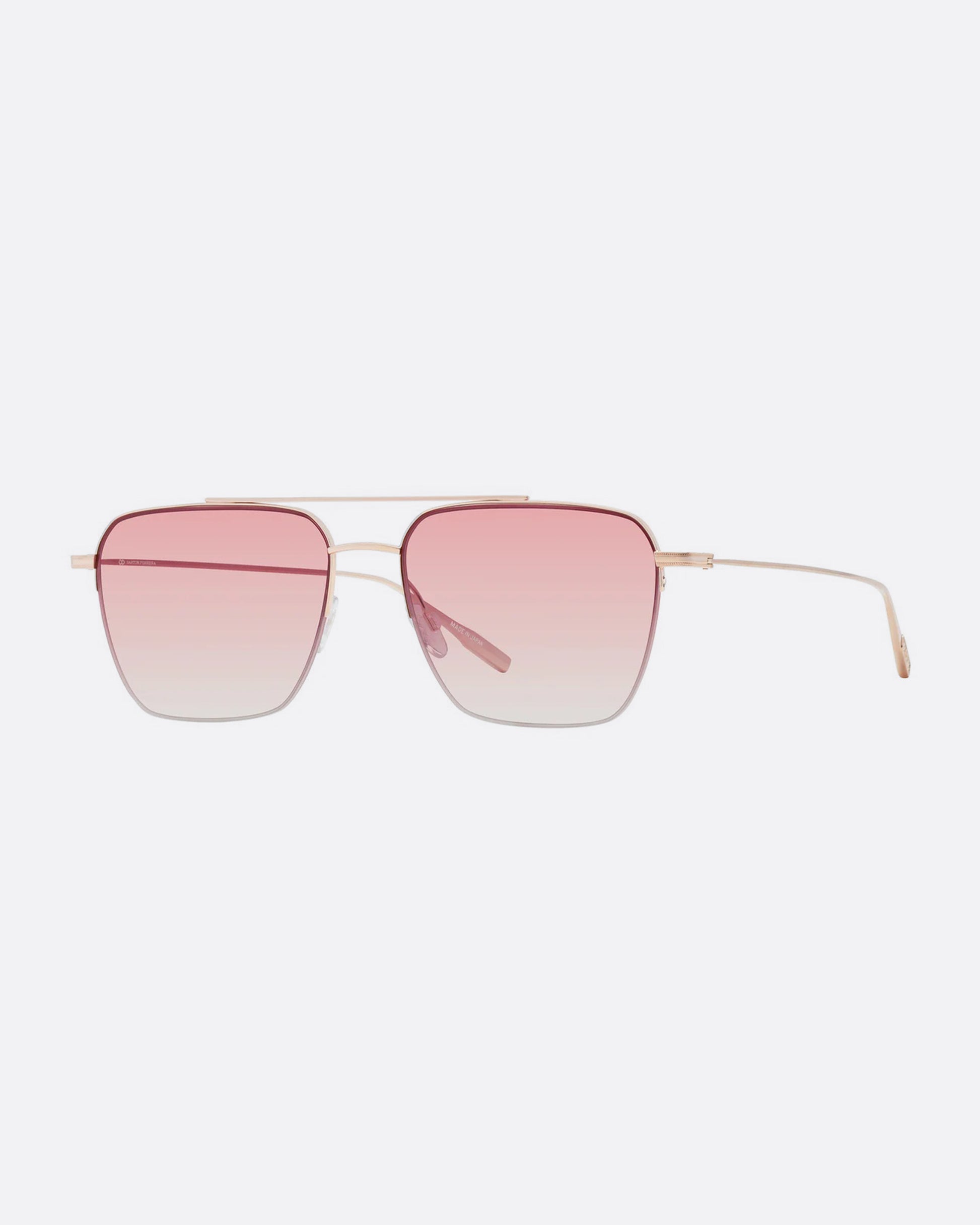 A pair of navigator sunglasses with pink gradient lenses. Shown diagonally from the front.