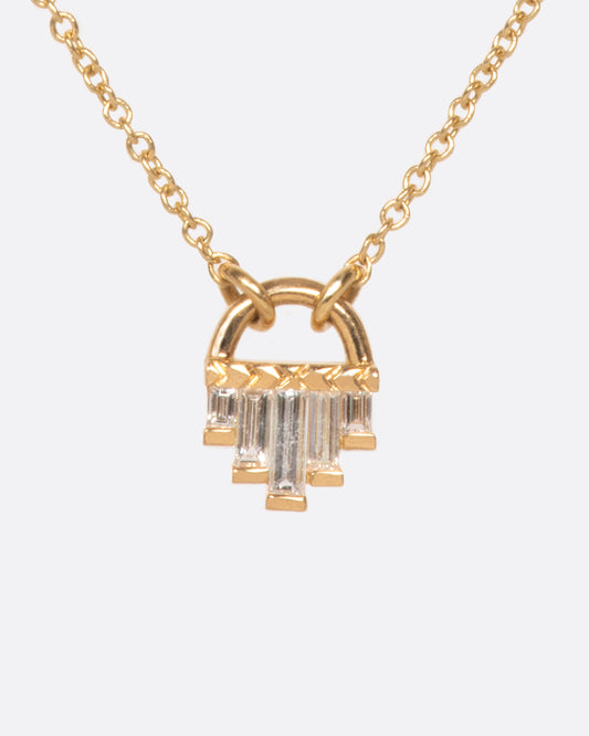 A curved gold pendant necklace with five diamond baguettes.