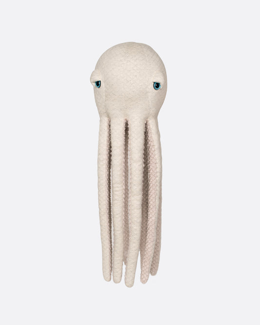 A stuffed plush oatmeal colored octopus with blue eyes and a fuzzy belly. Shown from the front.