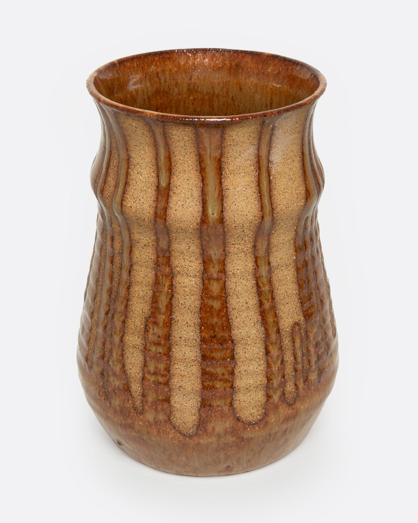 A tan ceramic vase with a dripped umber glaze, shown from the front.