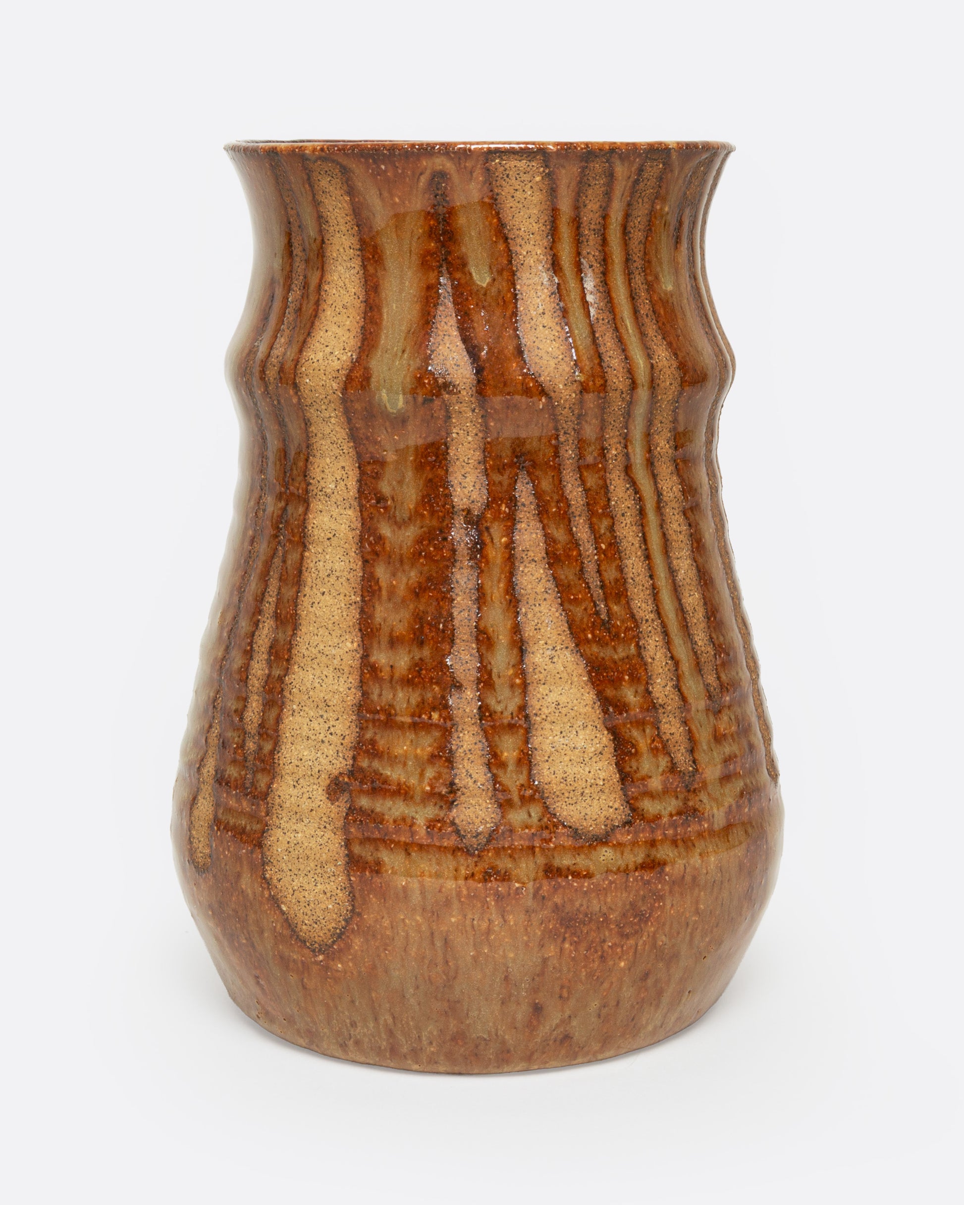 A tan ceramic vase with a dripped umber glaze, shown from the front.