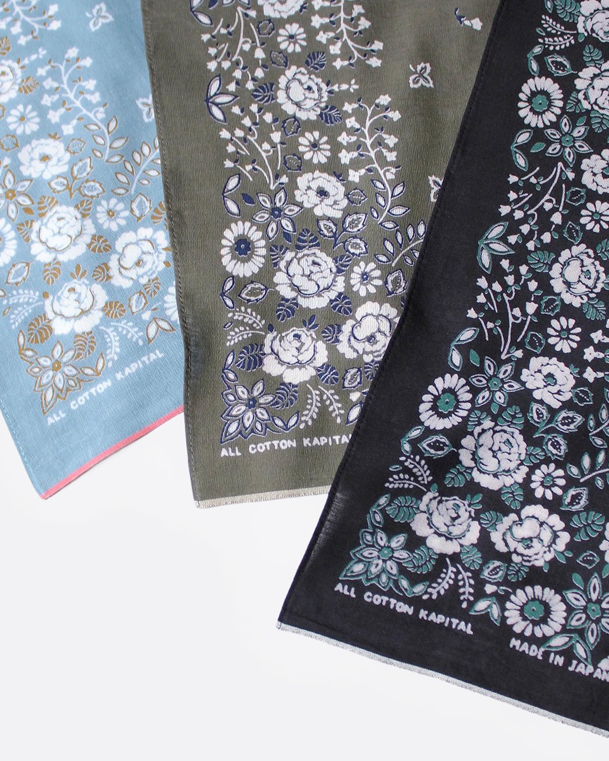 Three floral-patterned bandanas in blue, green, and black, shown close up.
