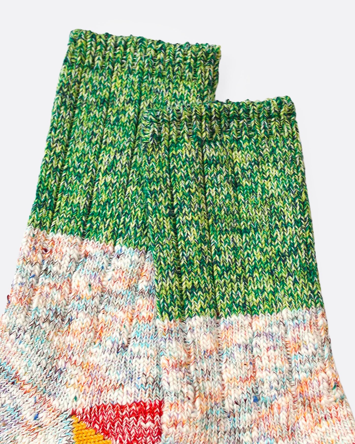 A close up of a pair of multicolored marl socks with dual-toned heels.