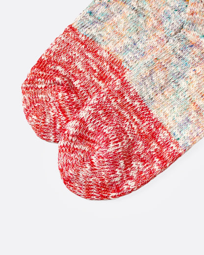A close up of a pair of multicolored marl socks with dual-toned heels, shown from the side.