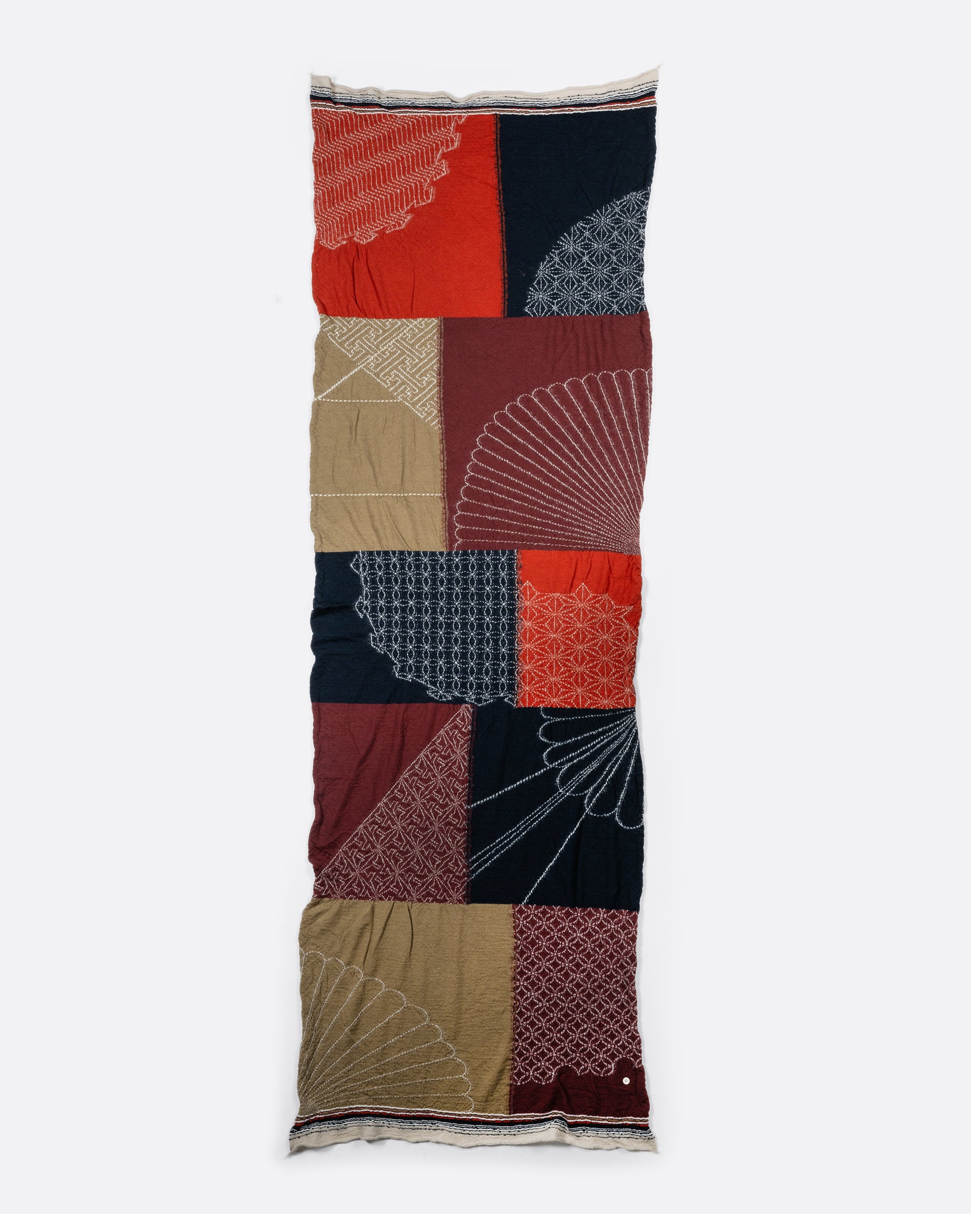 A red patchwork wool scarf. View laying flat.