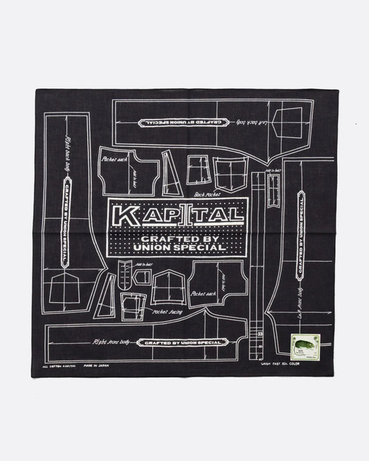 A black cotton bandana with a  pattern for a Barbie sized outfit in white and 'KAPITAL CRAFTED BY UNION SPECIAL' at the center. Shown from the front.
