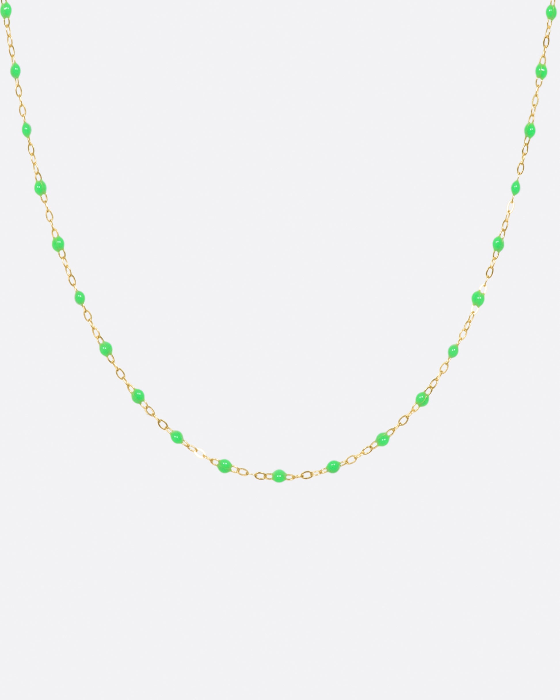 A thin yellow gold chain necklace with resin beads. Each necklace is hand dipped in melted resin to create the beaded effect. 