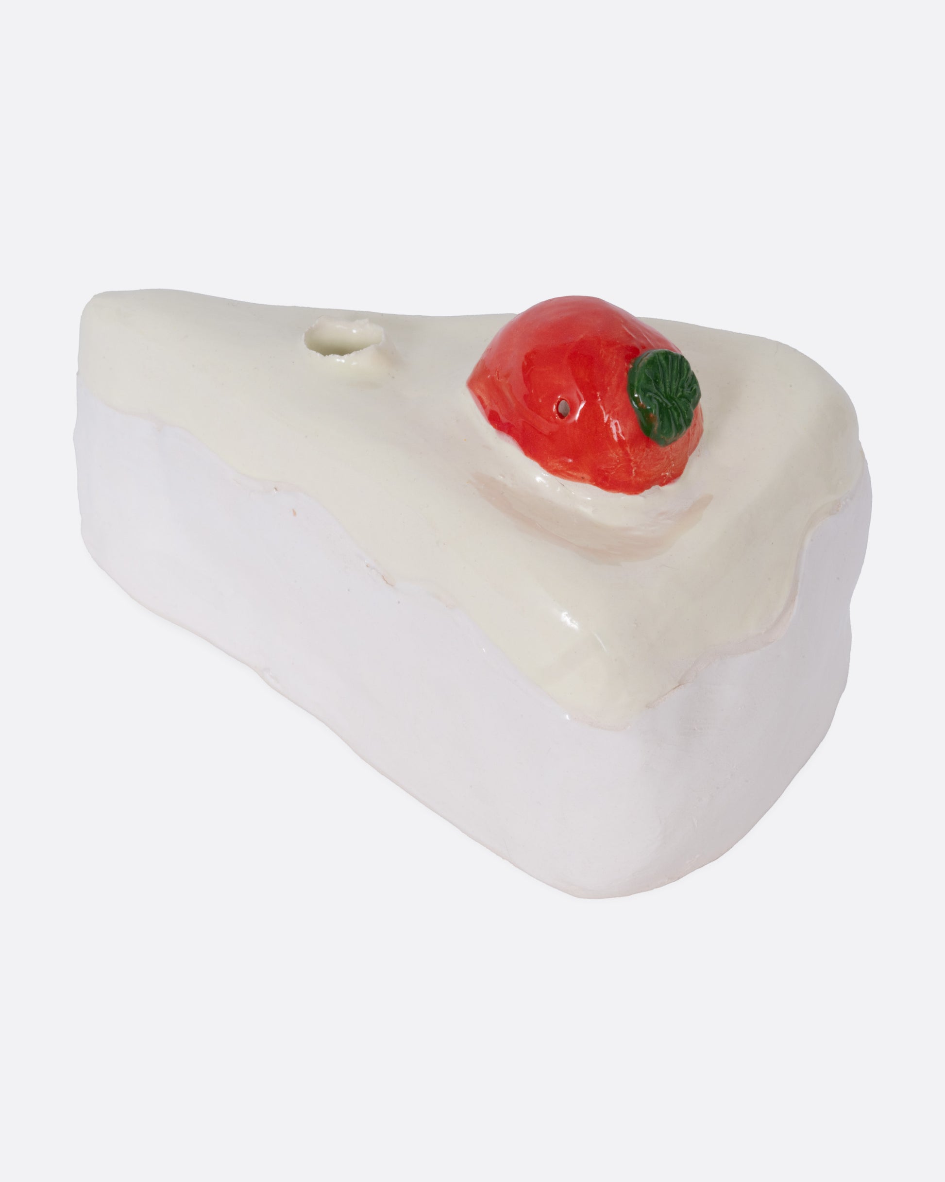 A ceramic cake slice shaped candle holder, shown from the side.
