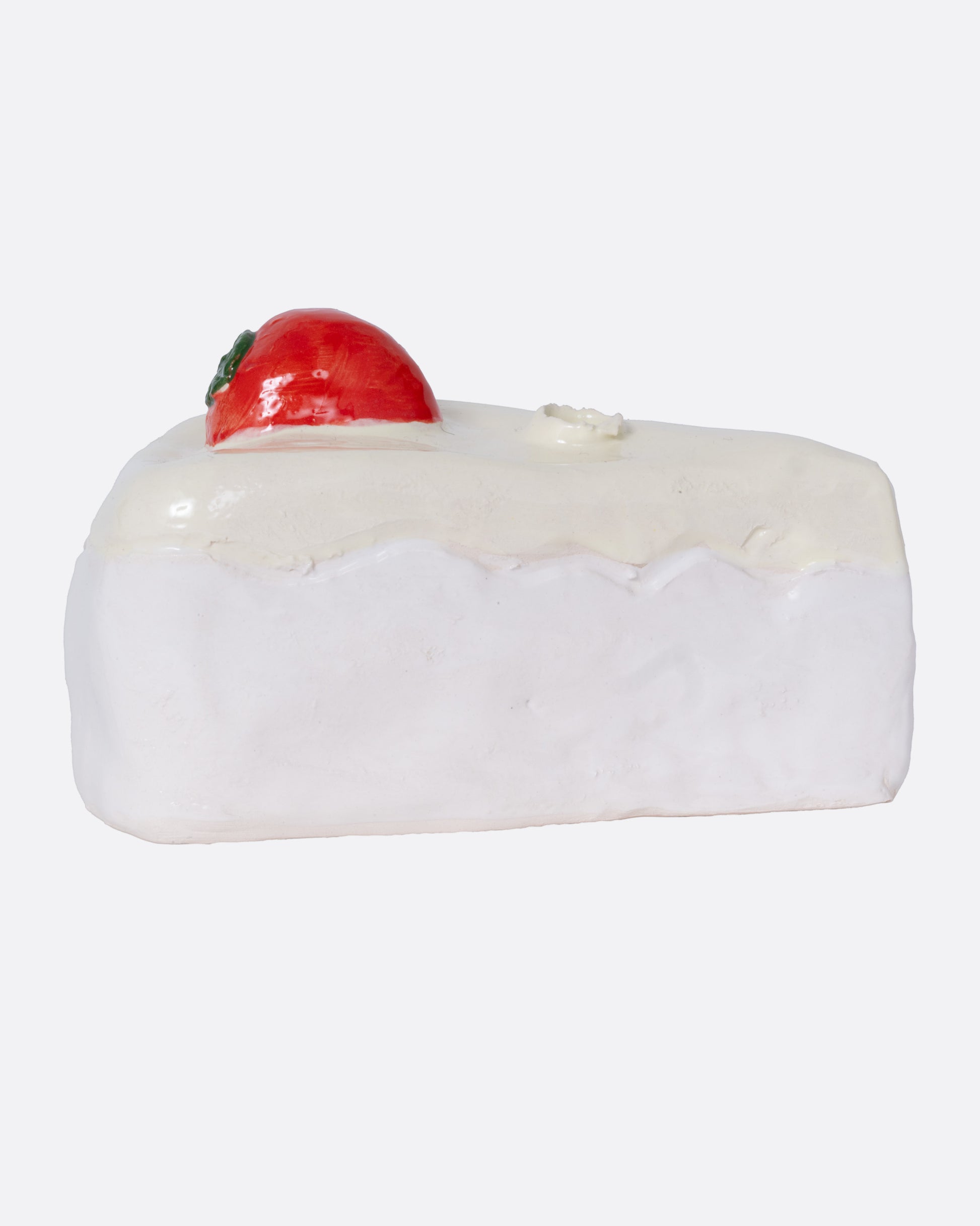 A ceramic cake slice shaped candle holder, shown from the side.