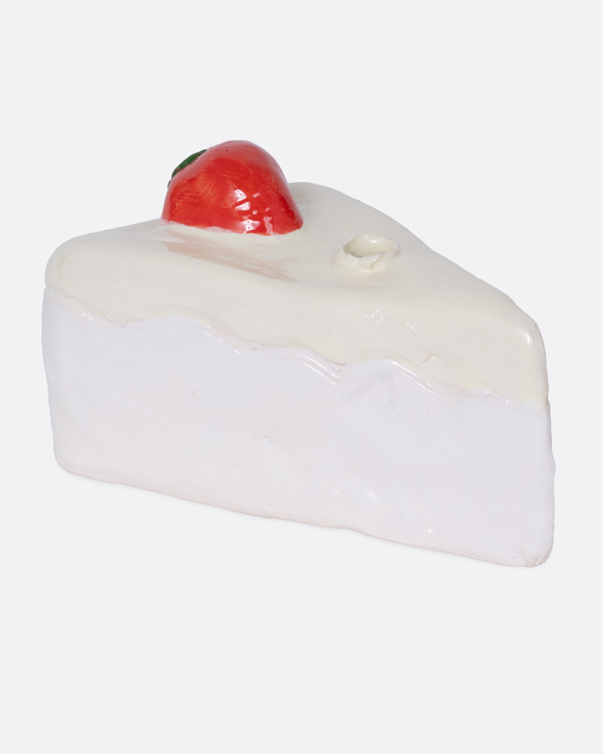 A ceramic cake slice shaped candle holder, shown from the side.