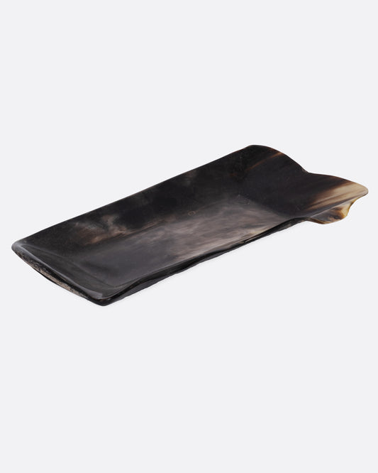 A rectangular buffalo horn tray with a natural edge and swirling deep brown and cream coloring, shown from the side.